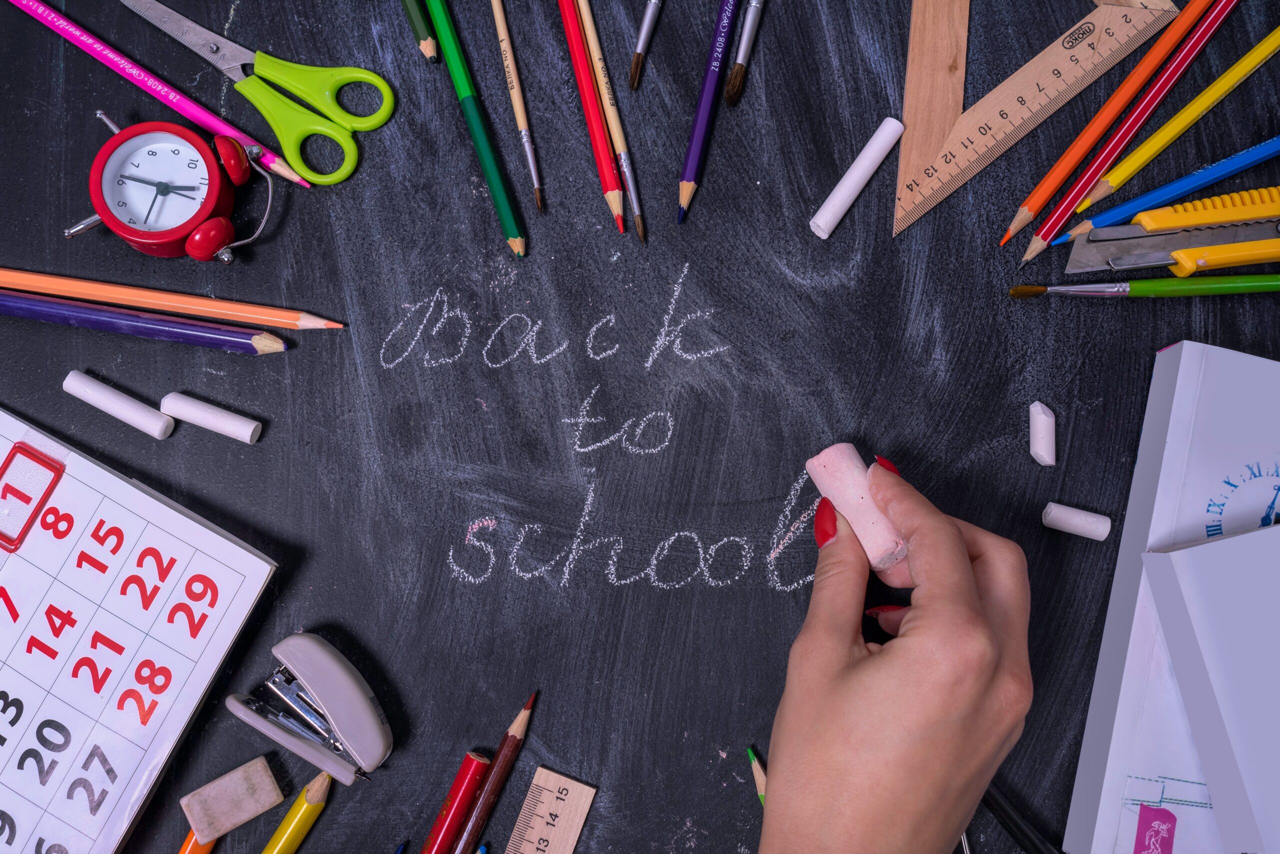 Fournitures scolaires autour de l’inscription « Back to school » sur un tableau
