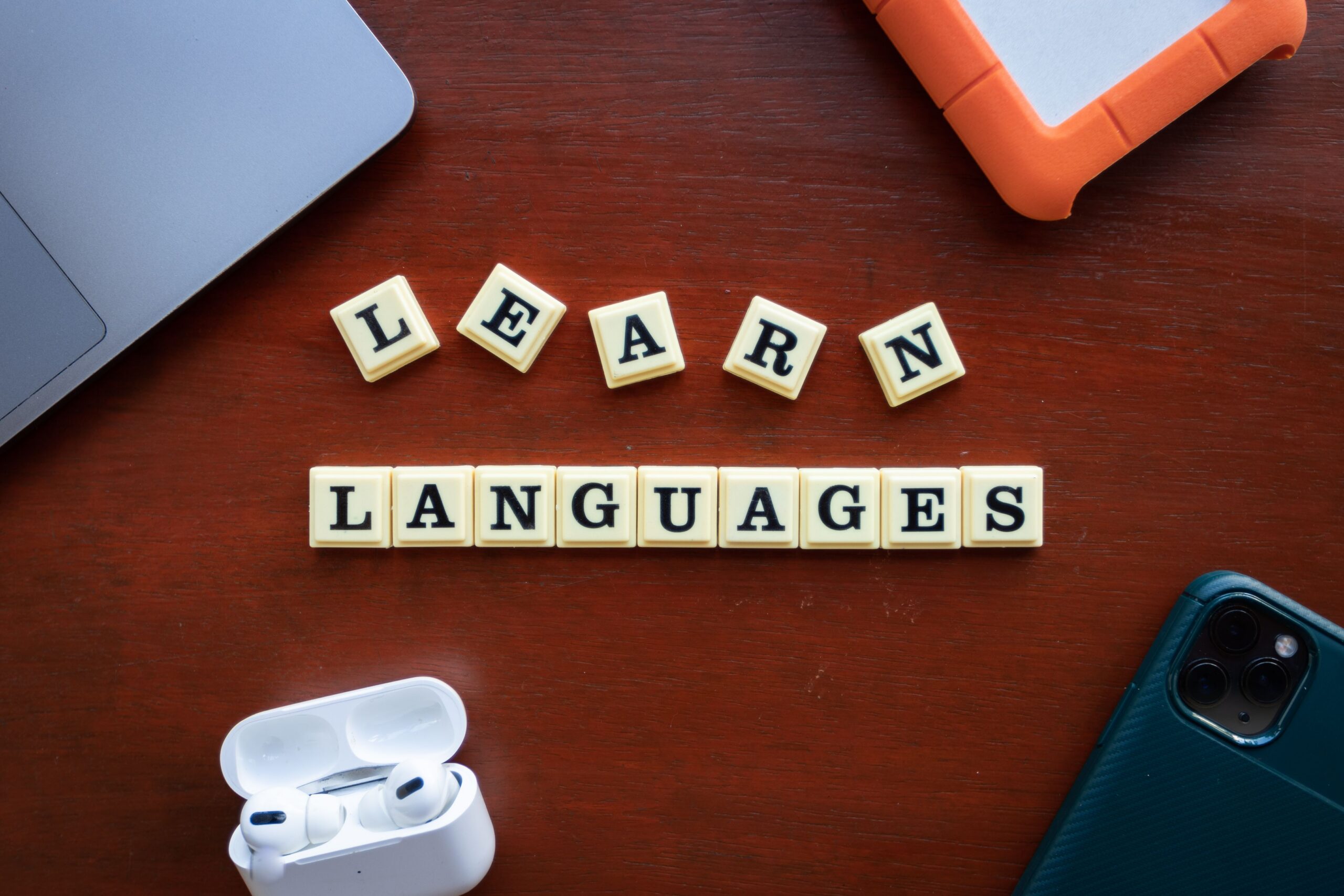 Lettres formant les mots « Learn languages » sur une table en bois
